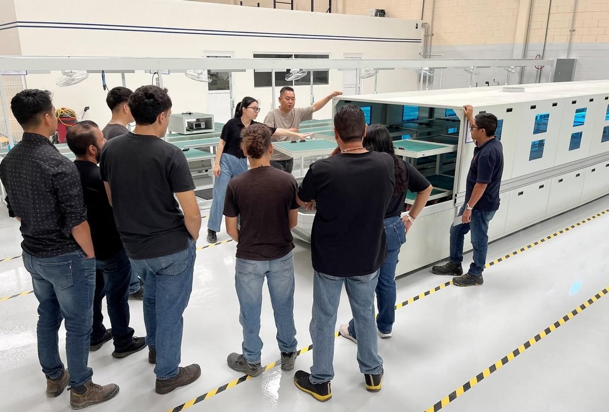 Equipo de Startek frente al horno de reflujo durante una revisión de proceso